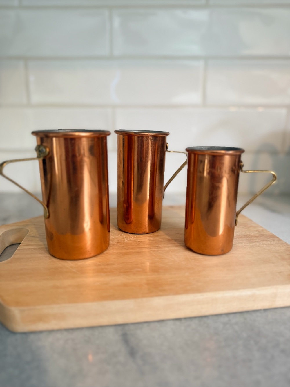 Vintage heavy copper and brass measuring cups set for kitchen or decor